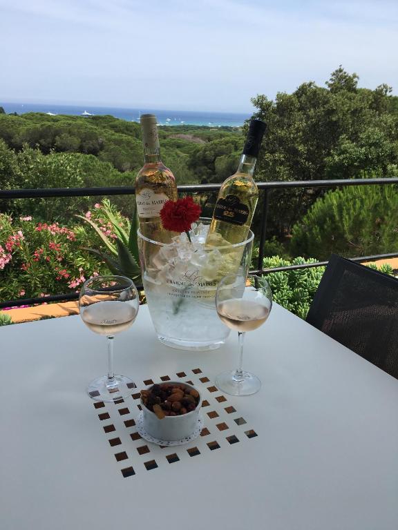 a bottle of wine and two glasses on a table at Hôtel les Bouis - Vue mer in Saint-Tropez