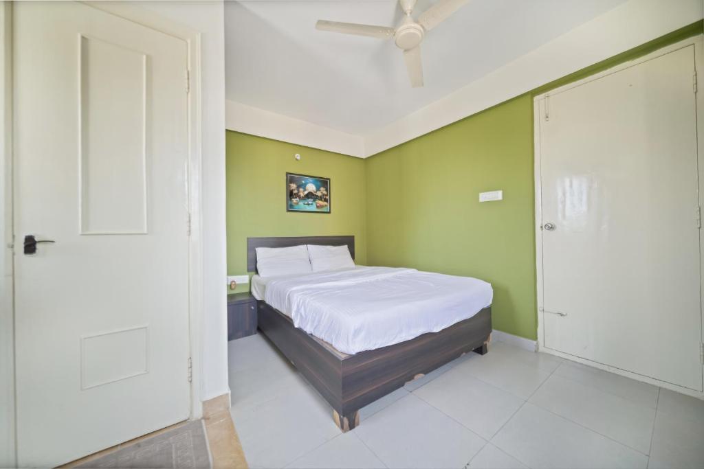 a bedroom with a bed and a green wall at Stayhome Classic in Bangalore