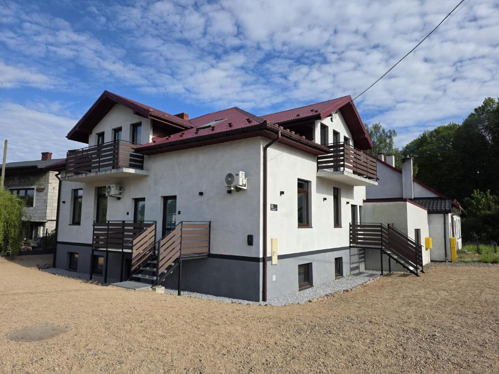 una grande casa bianca con balconi in legno di La Ville - Rouge a Zator