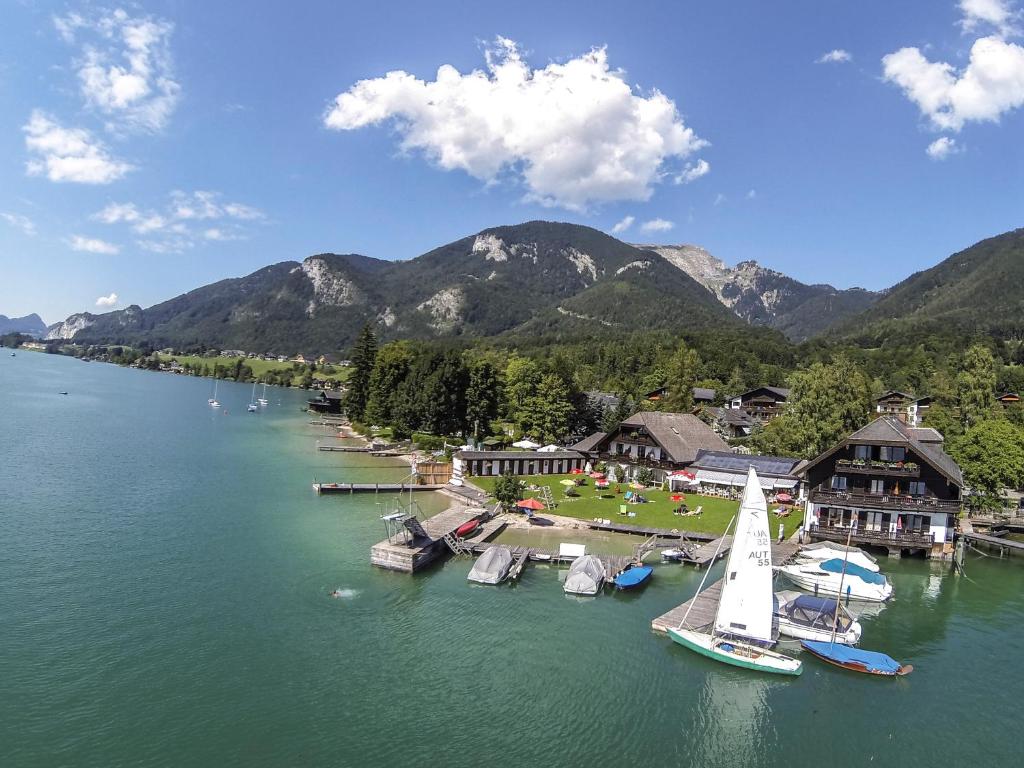 a group of boats are docked in a lake at Arndt's Bootshaus in St. Wolfgang