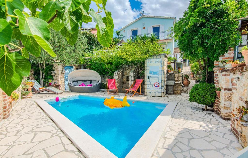 a swimming pool with a toy in a backyard at Cozy Home In Maslenica With Kitchen in Maslenica