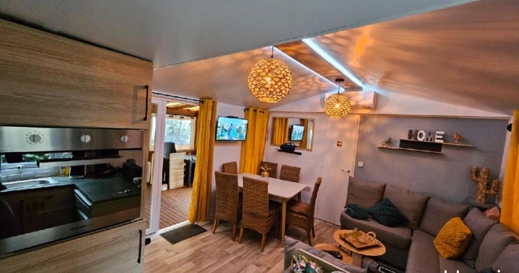 una sala de estar con un sofá y una mesa en MOBILE-HOME Bonne Anse plage, en Les Mathes