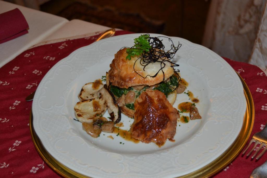 a white plate with food on a table at Hotel da Beppe Sello in Cortina dʼAmpezzo