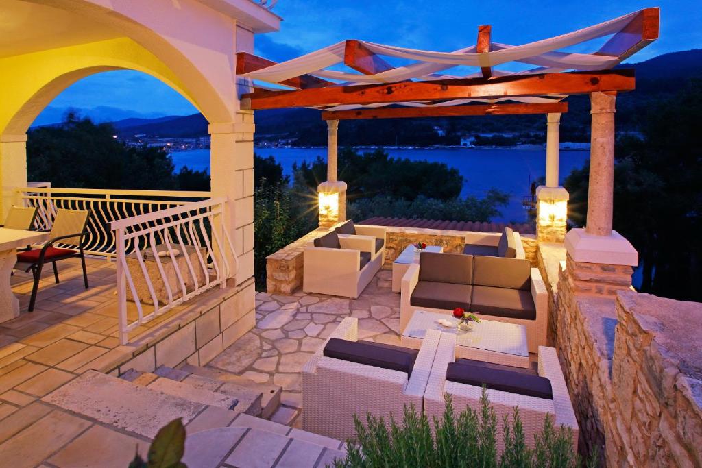 eine Terrasse mit Sofas und einer Pergola in der Nacht in der Unterkunft Hotel Villa Telenta in Vela Luka