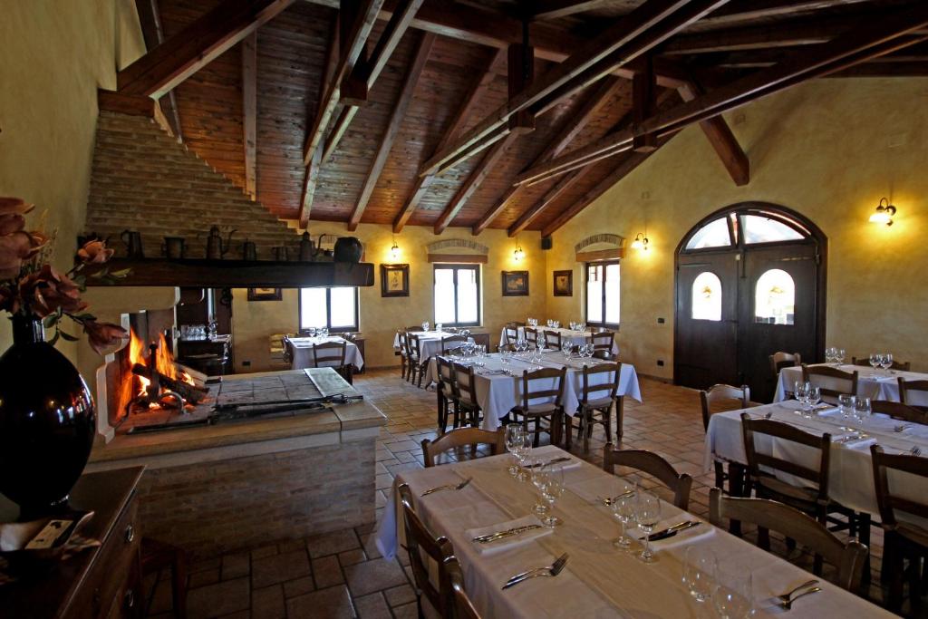 een eetkamer met tafels en stoelen en een open haard bij Rooms Alla Beccaccia in Fažana