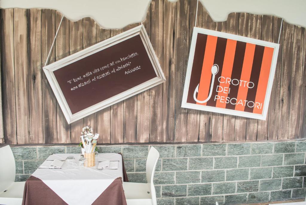 une salle à manger avec une table et des affiches sur le mur dans l'établissement Crotto dei Pescatori, à Lezzeno