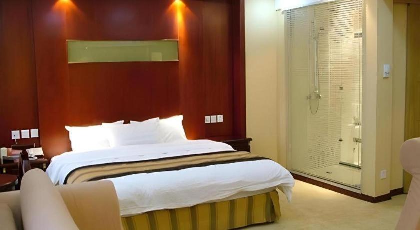 Ένα ή περισσότερα κρεβάτια σε δωμάτιο στο Heilongjiang Kunlun Hotel