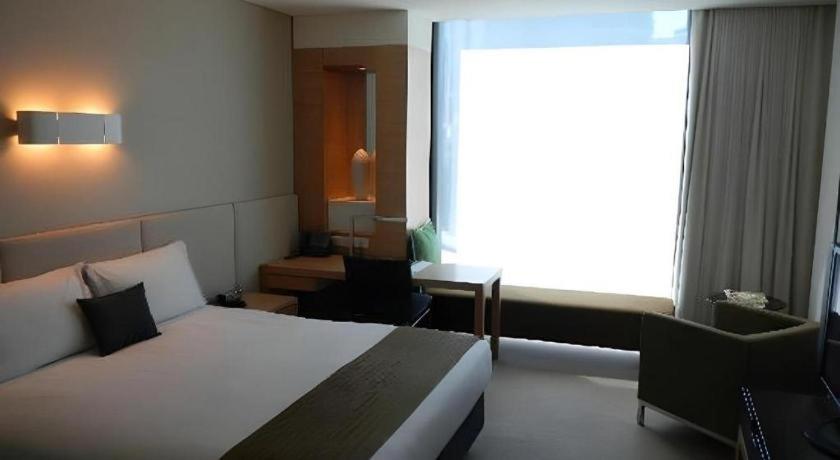 a hotel room with a bed and a window at GreenTree Inn Taicang Baolong Square Hotel in Taicang
