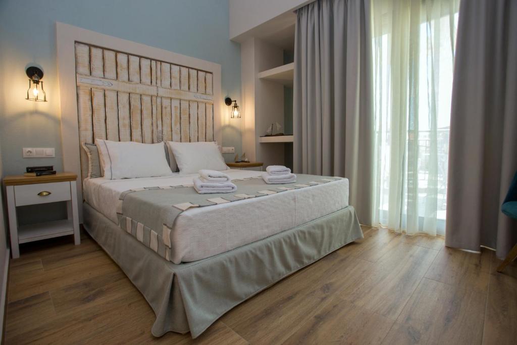 um quarto com uma cama grande e uma janela grande em The Five Keys Apartments em Limenaria