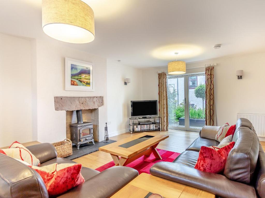 een woonkamer met een bank en een open haard bij Rose Cottage - Uk39245 in Inverness