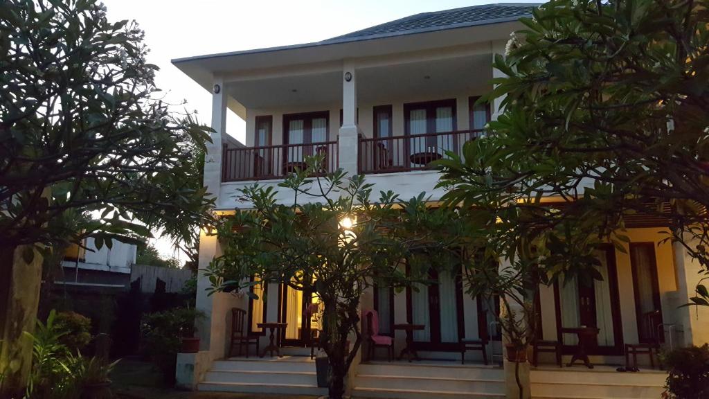 dom z drzewami przed nim w obiekcie Keke Homestay Sanur w mieście Sanur