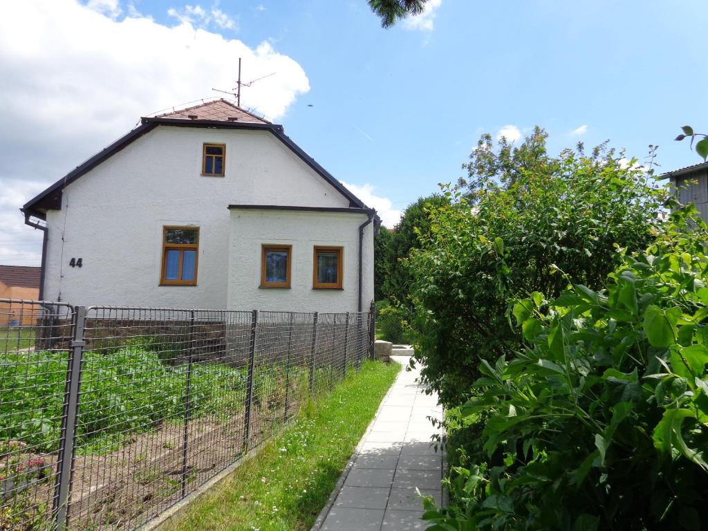 una casa blanca con una valla delante en Apartmán Bára, en Český Krumlov