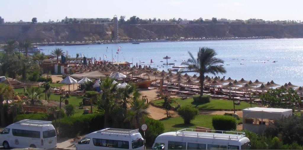 einen Strand mit Sonnenschirmen und einem Körper aus Wasser in der Unterkunft El Kheima Beach Resort in Sharm El Sheikh