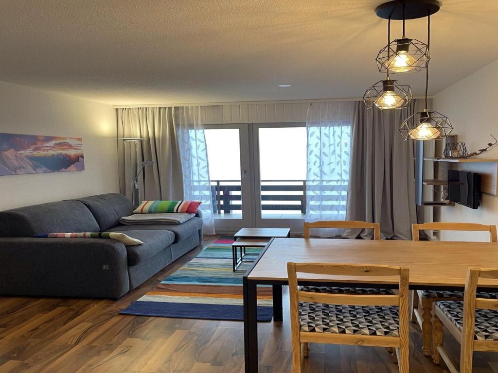 a living room with a couch and a table at Charming apartment with hill view in Veysonnaz