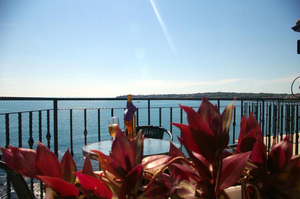 a table with red flowers and a view of the water at Sea View Apartments in Sozopol