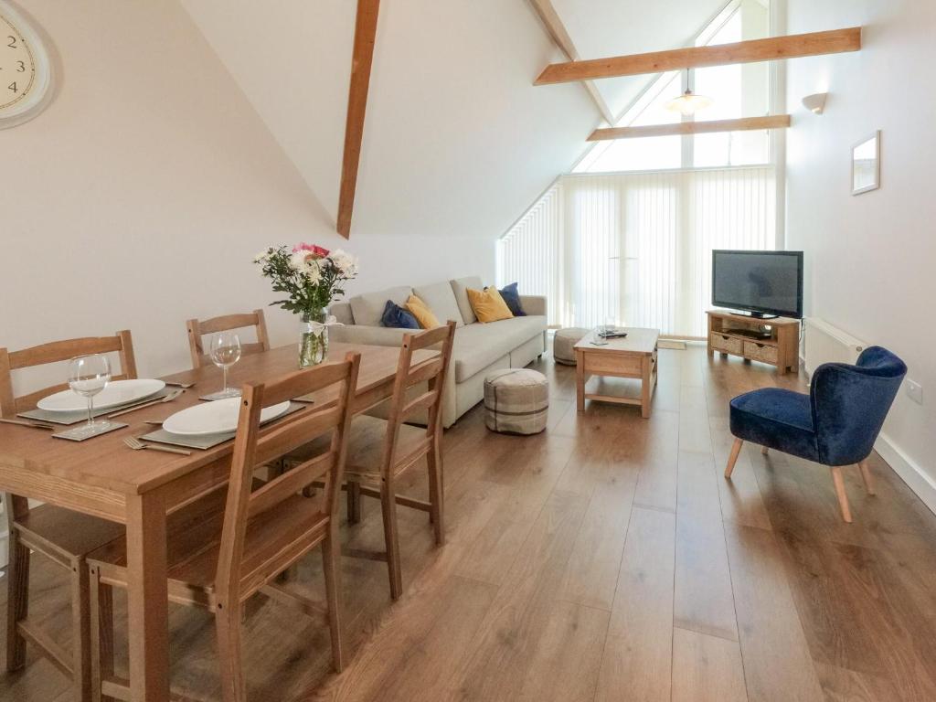 a living room with a dining table and a couch at Sea Is All Around in Mundesley