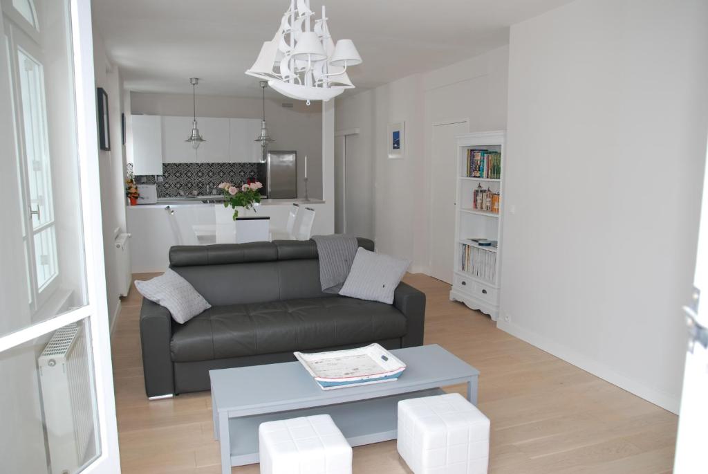 uma sala de estar com um sofá e uma mesa em Caboteurs em Le Pouliguen