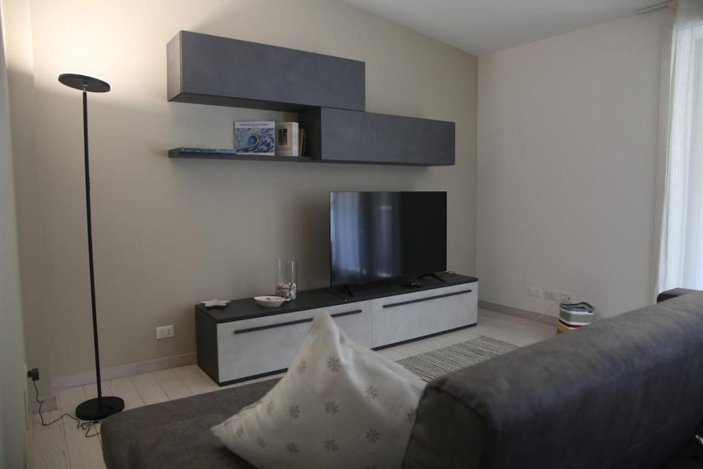 a living room with a couch and a flat screen tv at A Casa di Lilly in Albenga