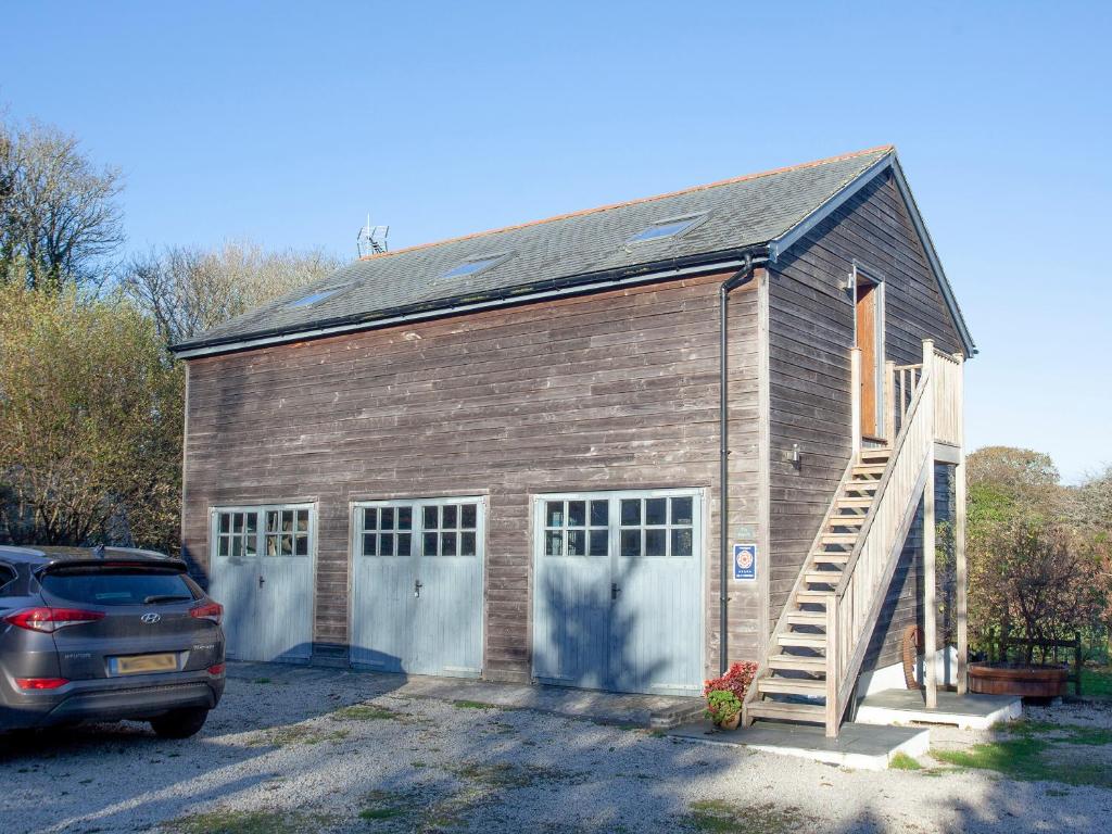 a barn with two doors and a car parked in front at The Hayloft - Uk36516 in Germoe
