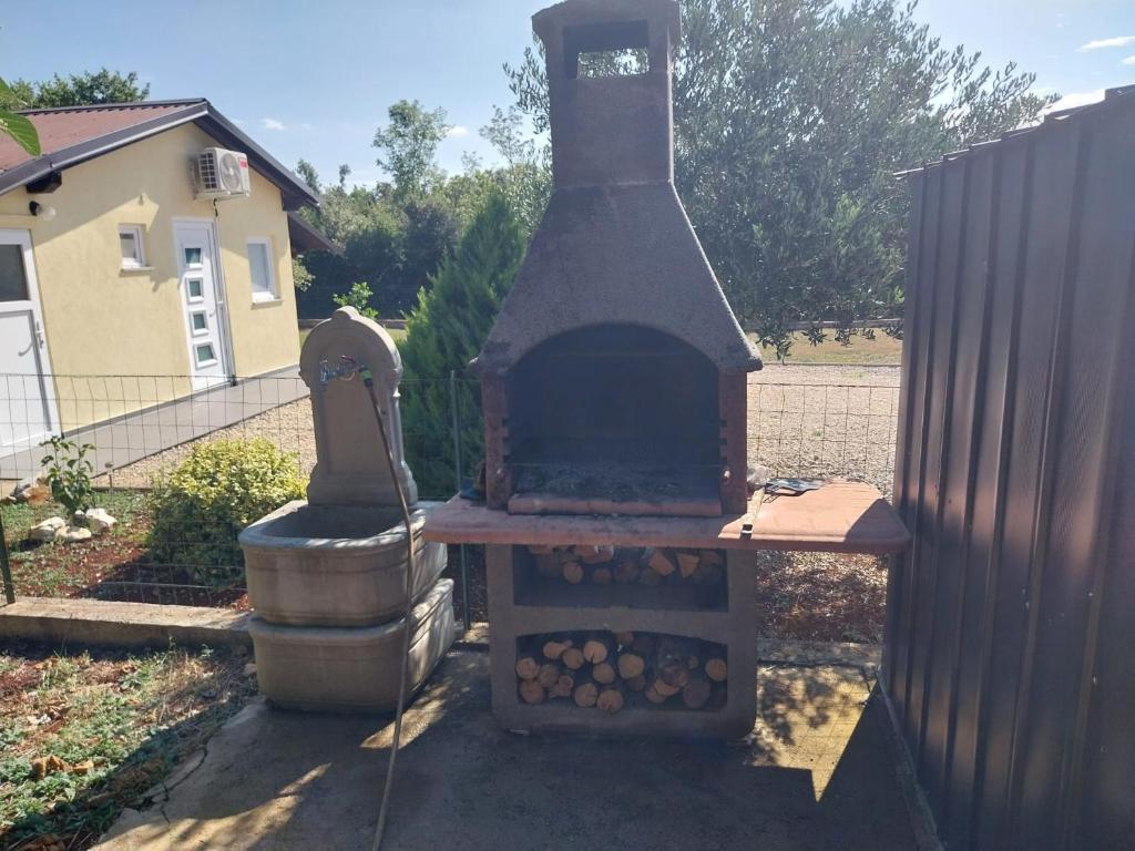 Neben einem Zaun befindet sich ein Außenofen. in der Unterkunft Gabriella in Valtura