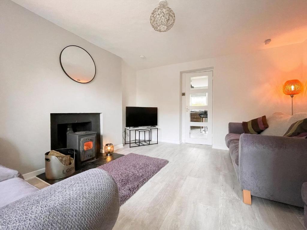 a living room with a couch and a fireplace at Academy Street Cottage in Tain