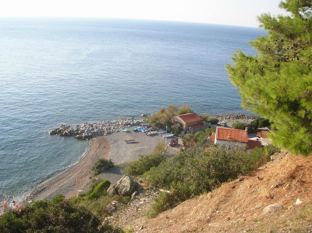 a view of a beach with a house and the ocean at Casetta Azzurra in Pomonte