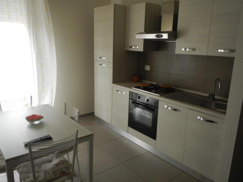 a kitchen with a table and a stove top oven at Appartamento Villarosa in Siracusa