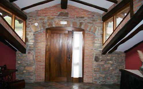 a room with a wooden door and a brick wall at Argiñenea in Berástegui