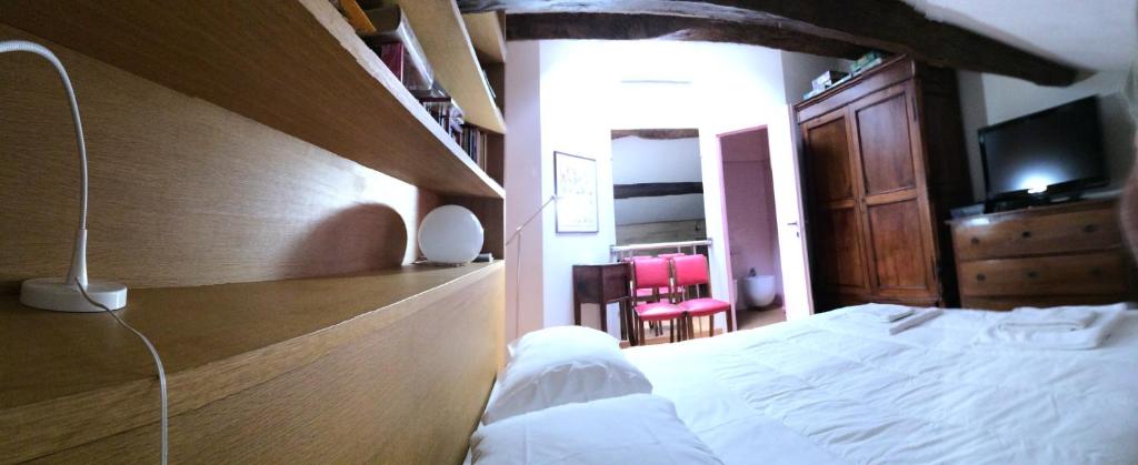 a bedroom with a bed and a dresser with a television at Appartamento Louer 2 in Parma