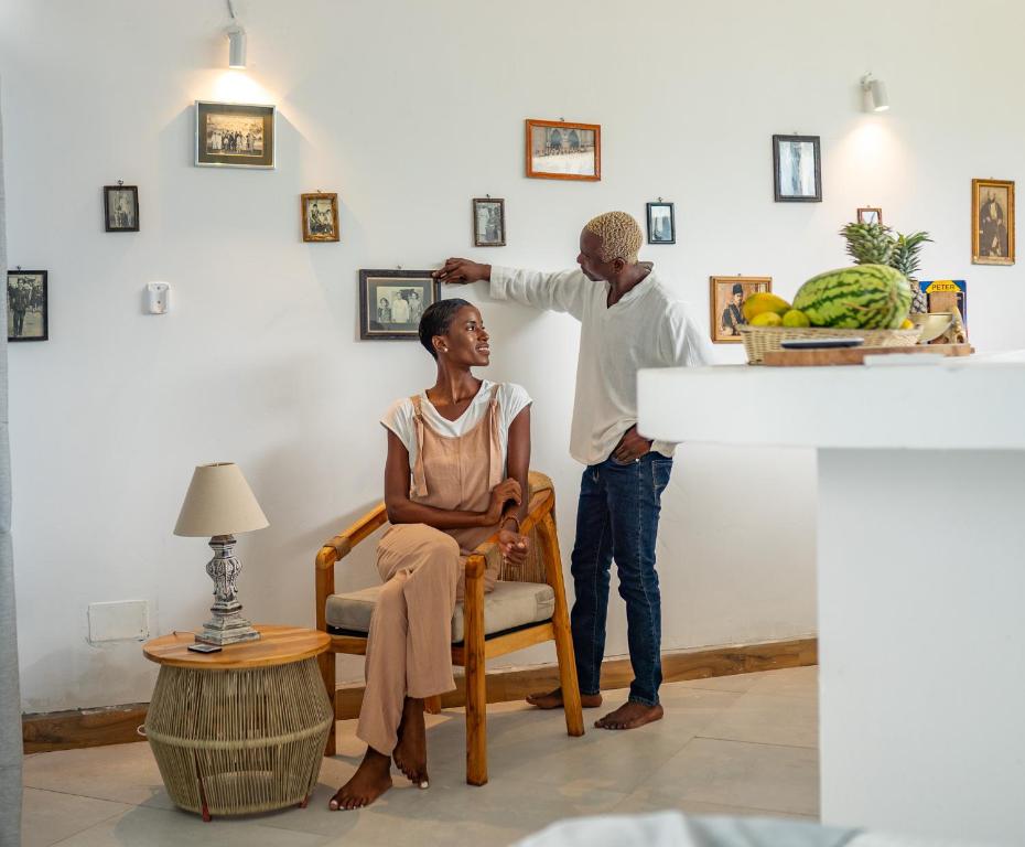 a man helping a woman get her hair cut at Pili Pili Tropical Island in Jambiani