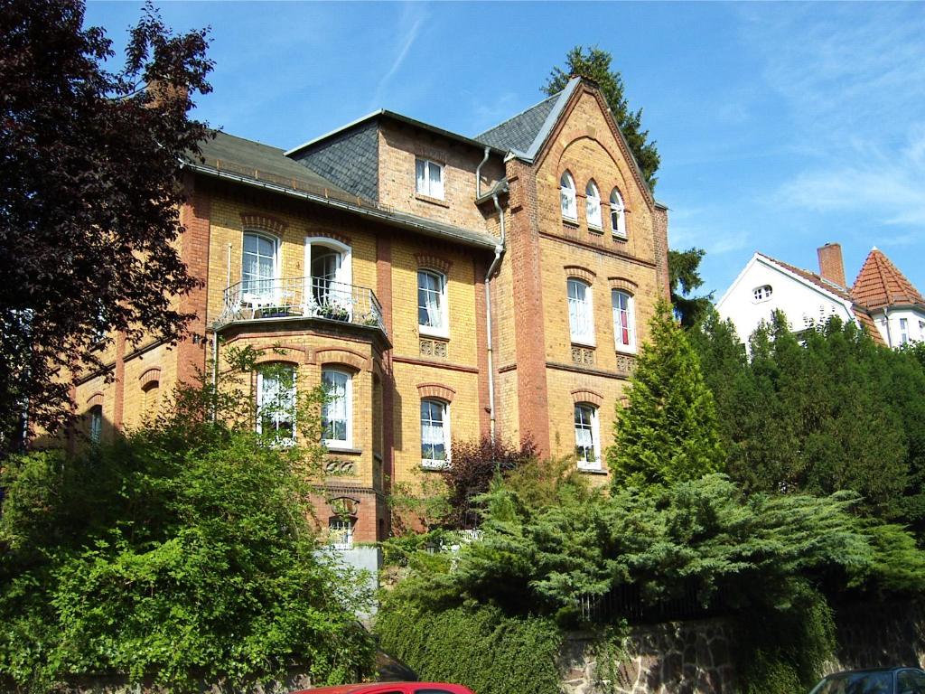 ein großes Backsteingebäude mit Balkon in der Unterkunft Pension und Ferienwohnung Christine Kilian in Eisenach