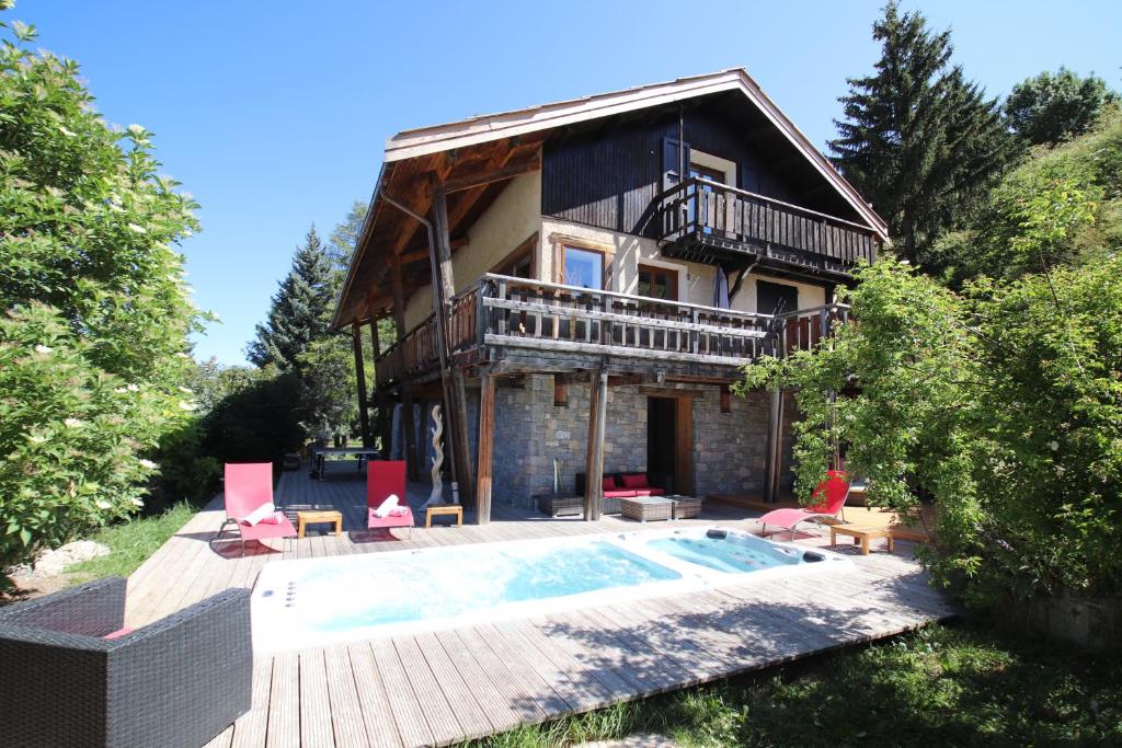 une maison avec une piscine devant dans l'établissement Chalet le Chantelevent for 24 Guests - Slope Views, Pool & Jacuzzi, à Vars