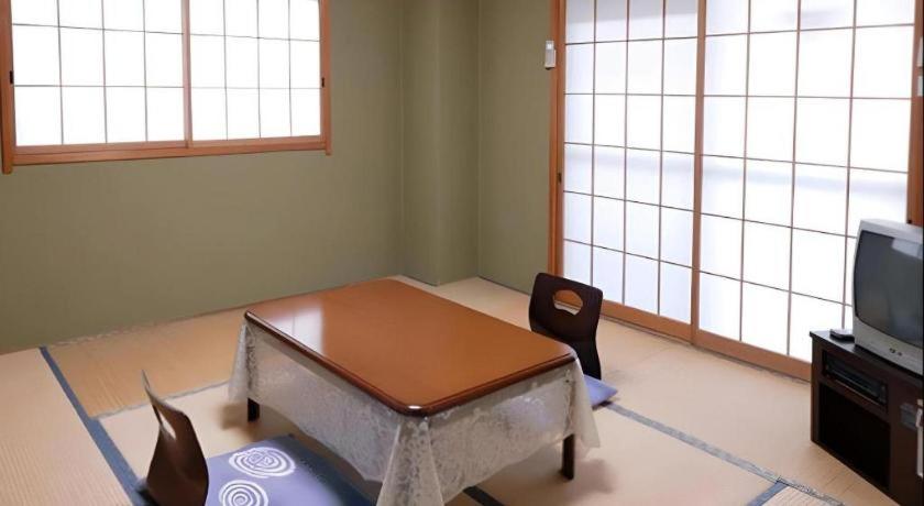 ein Wohnzimmer mit einem Couchtisch und einem TV in der Unterkunft Kinugawa Niouson Plaza Hotel in Nikko