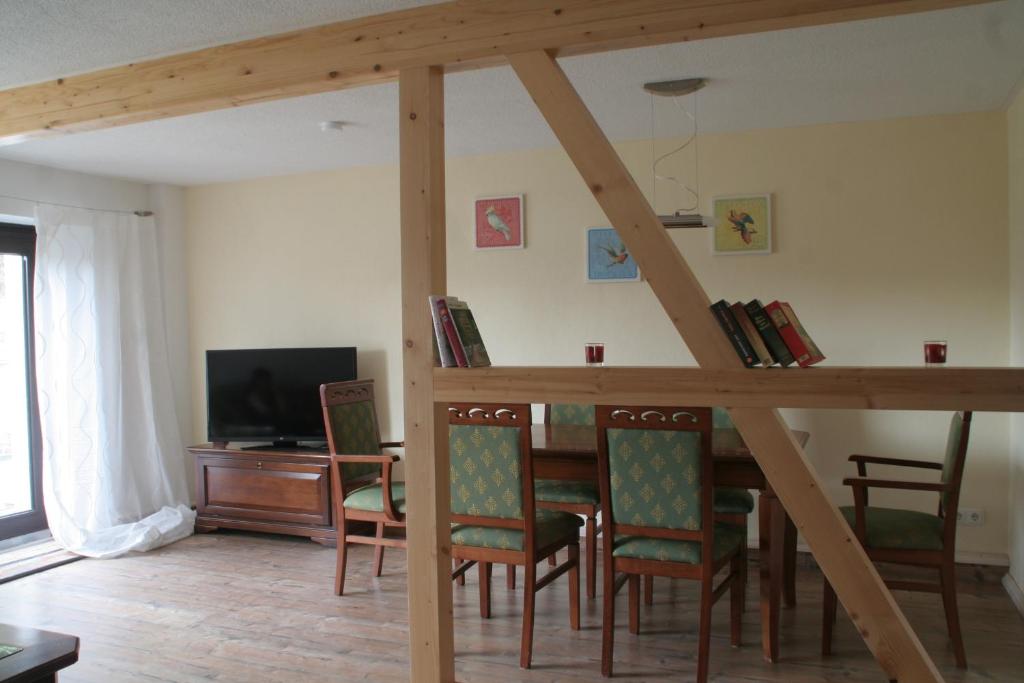 ein Wohnzimmer mit einem Tisch, Stühlen und einem TV in der Unterkunft Ferienhaus Geipel in Wohlbach