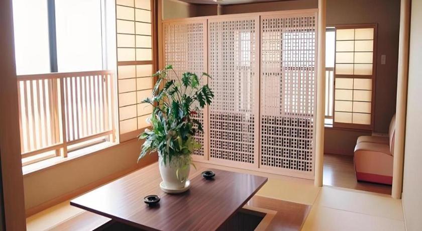 ein Wohnzimmer mit einem Tisch und einer Pflanze darauf in der Unterkunft Hotel Kaanapali in Shirako