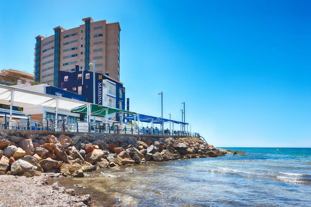einen Strand mit einem Gebäude und dem Meer in der Unterkunft Hotel Marina in Oropesa del Mar