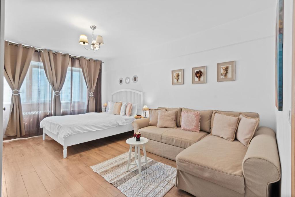 a white living room with a couch and a bed at Spitalul Bagdasar & Obregia - Sudului 507 by MRG Apartments in Bucharest