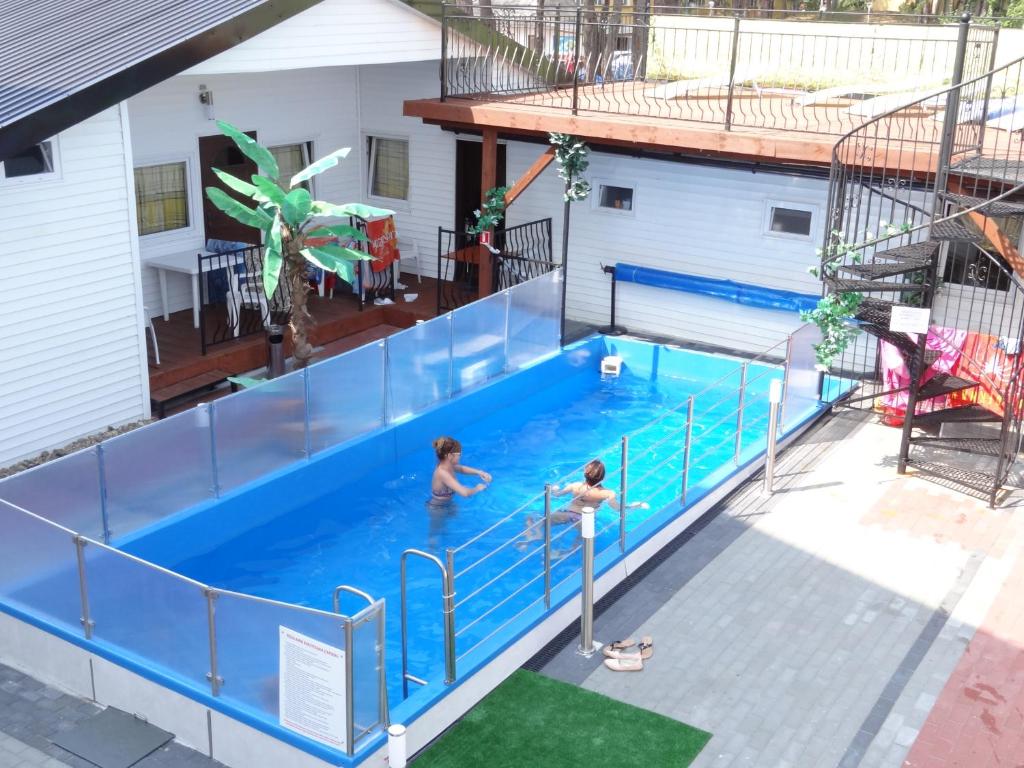 dos personas en una piscina en una casa en MAX Apartamenty - Pokoje - Domki - Restauracja - Basen, en Mielno