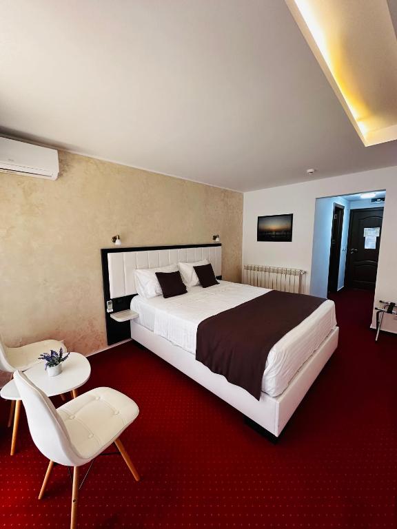 a bedroom with a large bed and a red carpet at Km ZerO - Vama Veche in Vama Veche