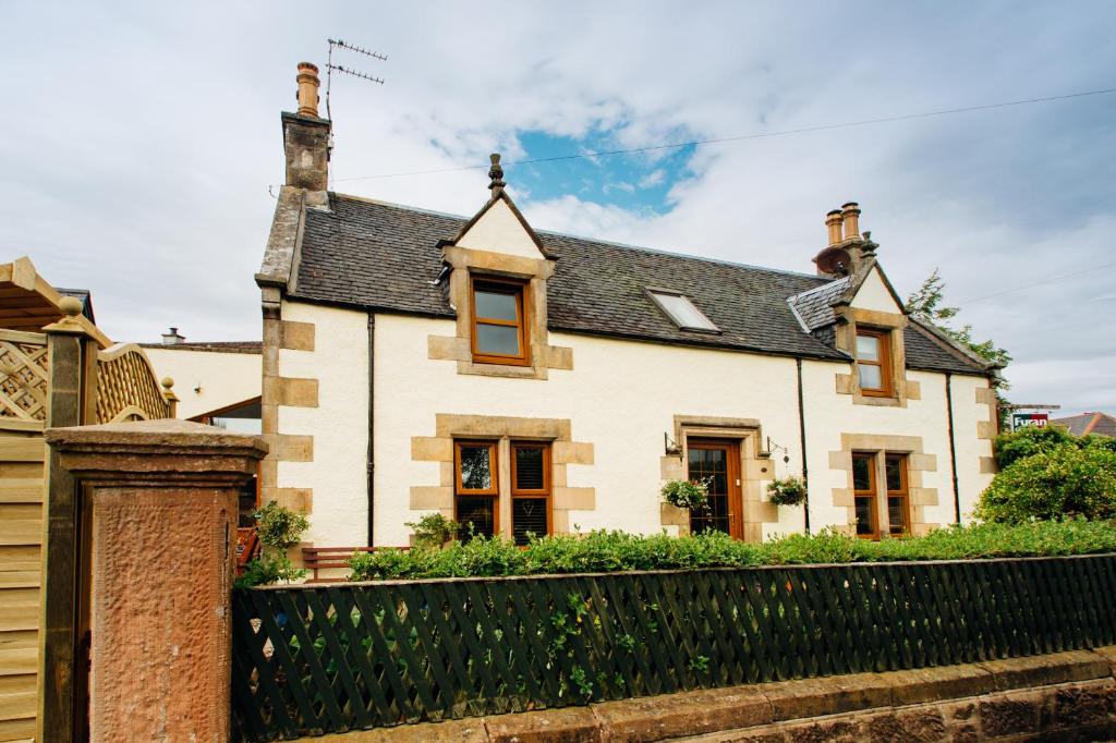 ein Haus mit einem schwarzen Zaun davor in der Unterkunft Furan GuestHouse in Inverness