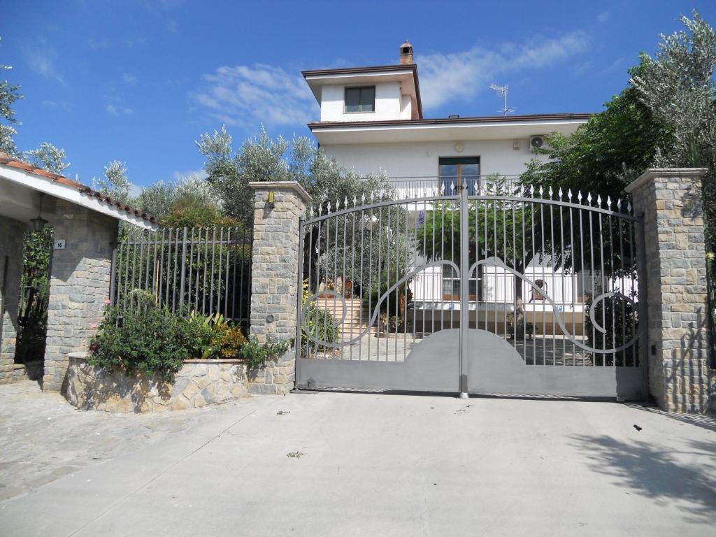 a gate in front of a white house at LA CASA di ROSA 