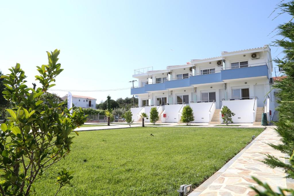 a large white building with a lawn in front of it at Kassiani Studios in Keramotí