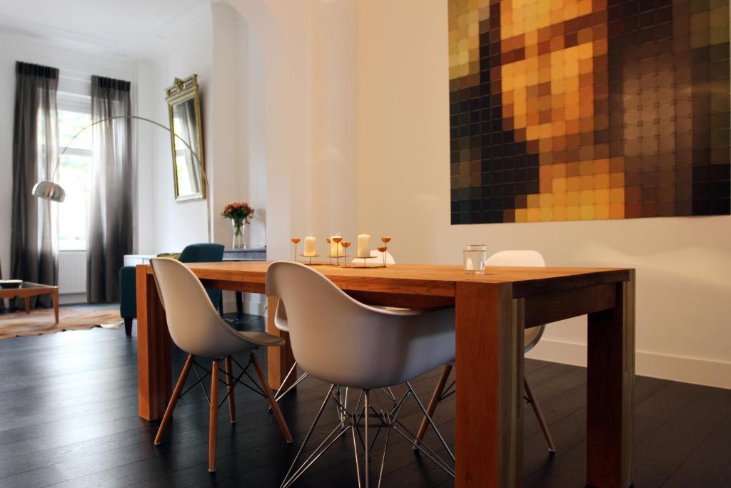 a dining room with a wooden table and chairs at Parc Brussels Apartment in Brussels