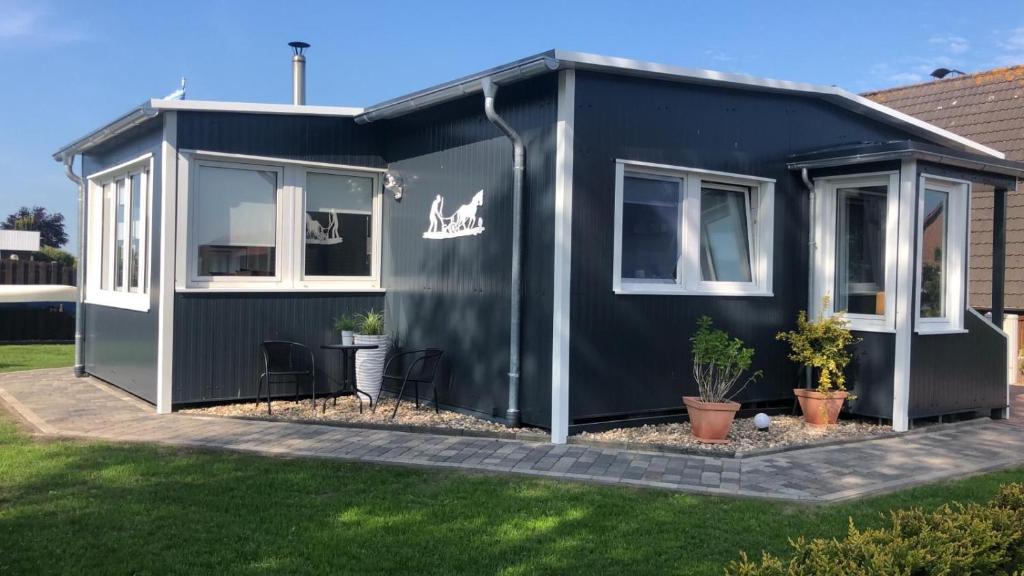 a black tiny house in a yard at Ferienhaus Ankerplatz in Bedekaspel