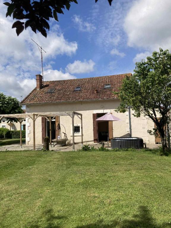 a white house with a large yard in front of it at Maison du bonheur SPA in Neuvic