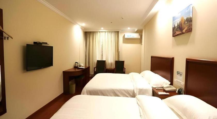ein Hotelzimmer mit zwei Betten und einem Flachbildfernseher in der Unterkunft GreenTree Inn Nanjing Gaochun District Old Street Scenic Spot Express Hotel in Chunxi