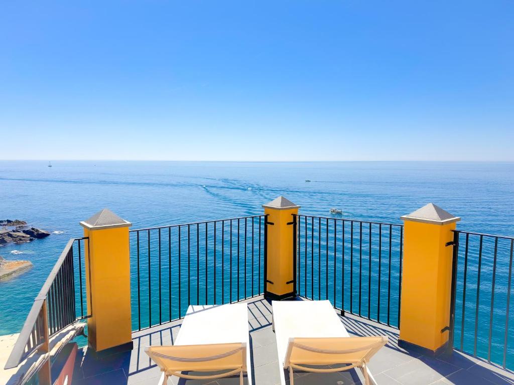 a balcony with tables and chairs overlooking the ocean at La Polena Camere Vernazza - Suite vista mare in Vernazza
