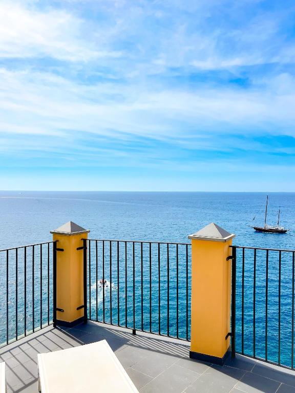 a balcony with a view of the ocean with a boat at La Polena Camere Vernazza - Suite vista mare in Vernazza