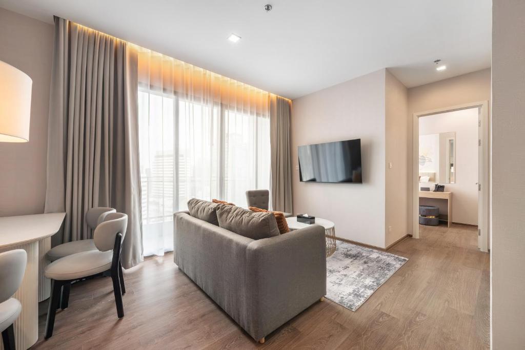 una sala de estar con un sofá y una mesa en The Rich Grand Residence Sukhumvit, en Bangkok