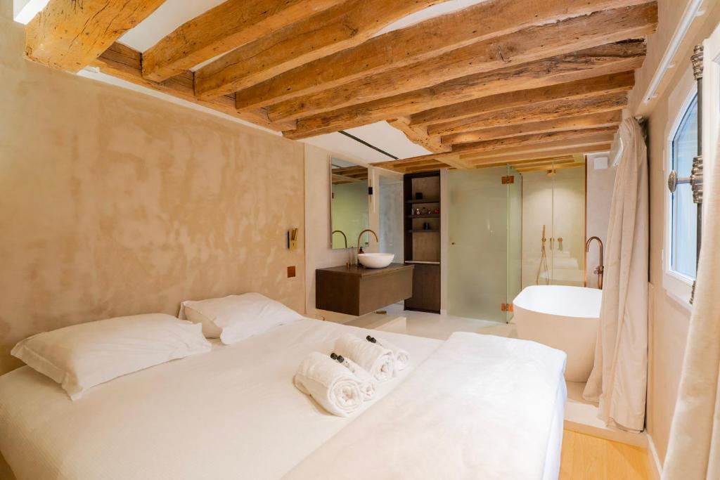 une chambre avec un lit blanc et une salle de bain dans l'établissement Séjour de luxe et haut de gamme au cœur de Paris, à Paris